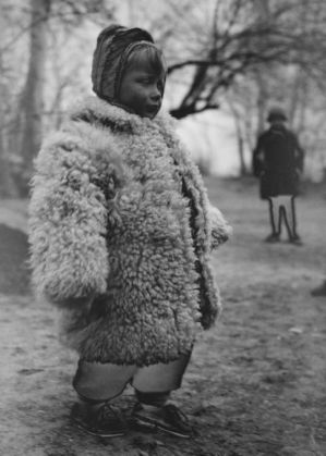 A-Polish-girl-wears-a-heavy-sheepskin-coat-at-a-refugee-camp